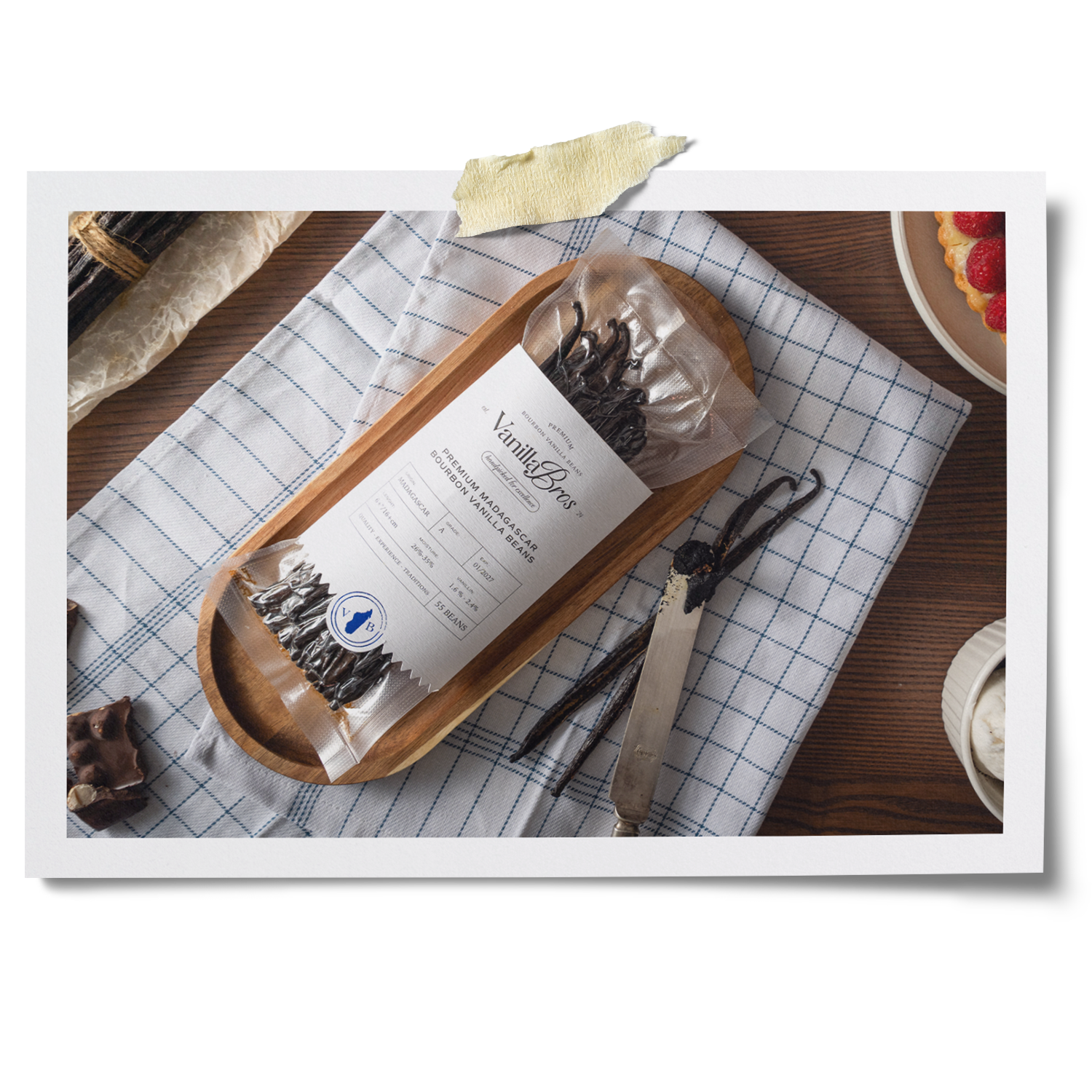 VanillaBros Premium Madagascar Bourbon Vanilla Beans package on wooden tray with whole vanilla pods and gourmet desserts
